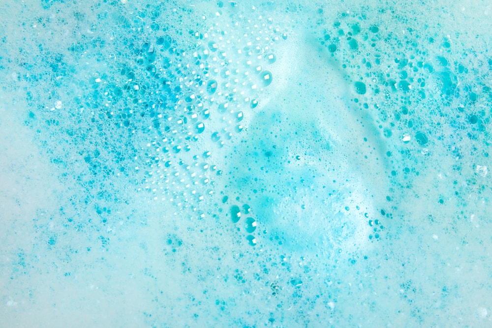 Bright blue bubbles from using a bath bomb